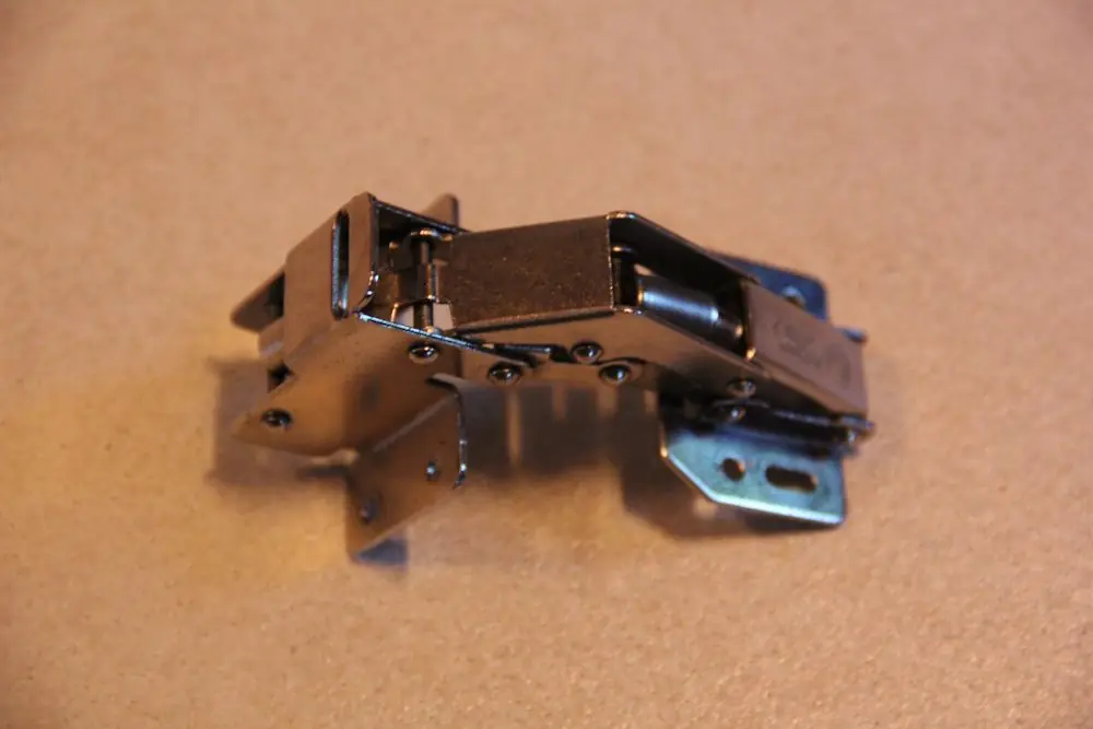 A concealed cabinet hinge fitted to the inside of a cabinet door and frame