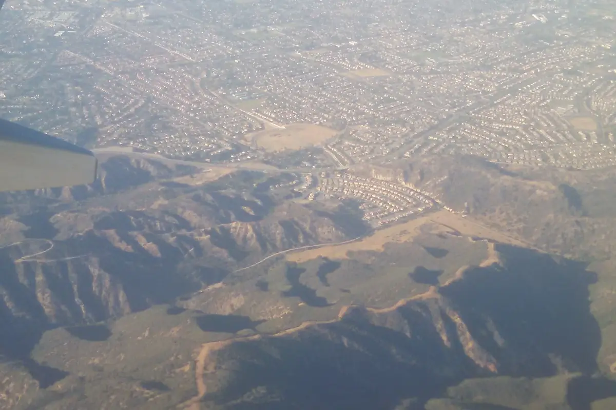 Aerial view over the hills south of Corona CA with the city's tract housing spread out beyond them