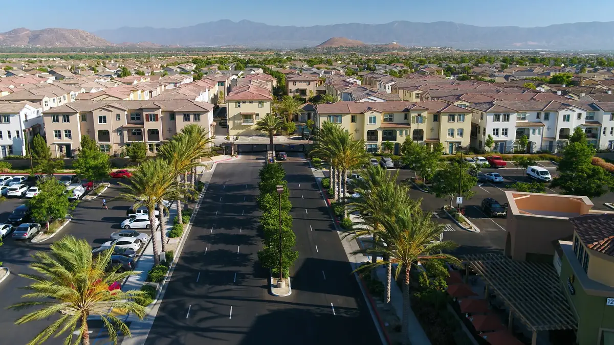 Aerial view of newer multi family and tract housing in Eastvale California with the mountains behind