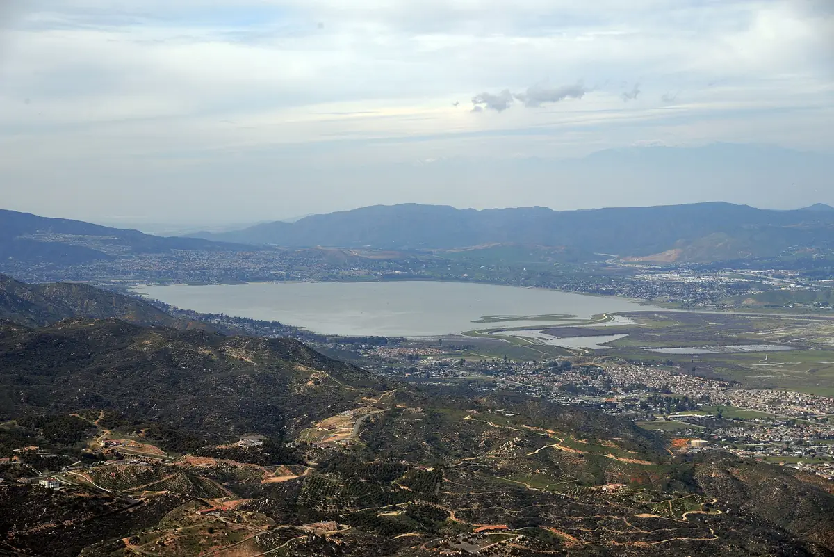 Aerial photograph of Lake Elsinore California with the lake in the centre, surrounding hills and residential development along the shoreline