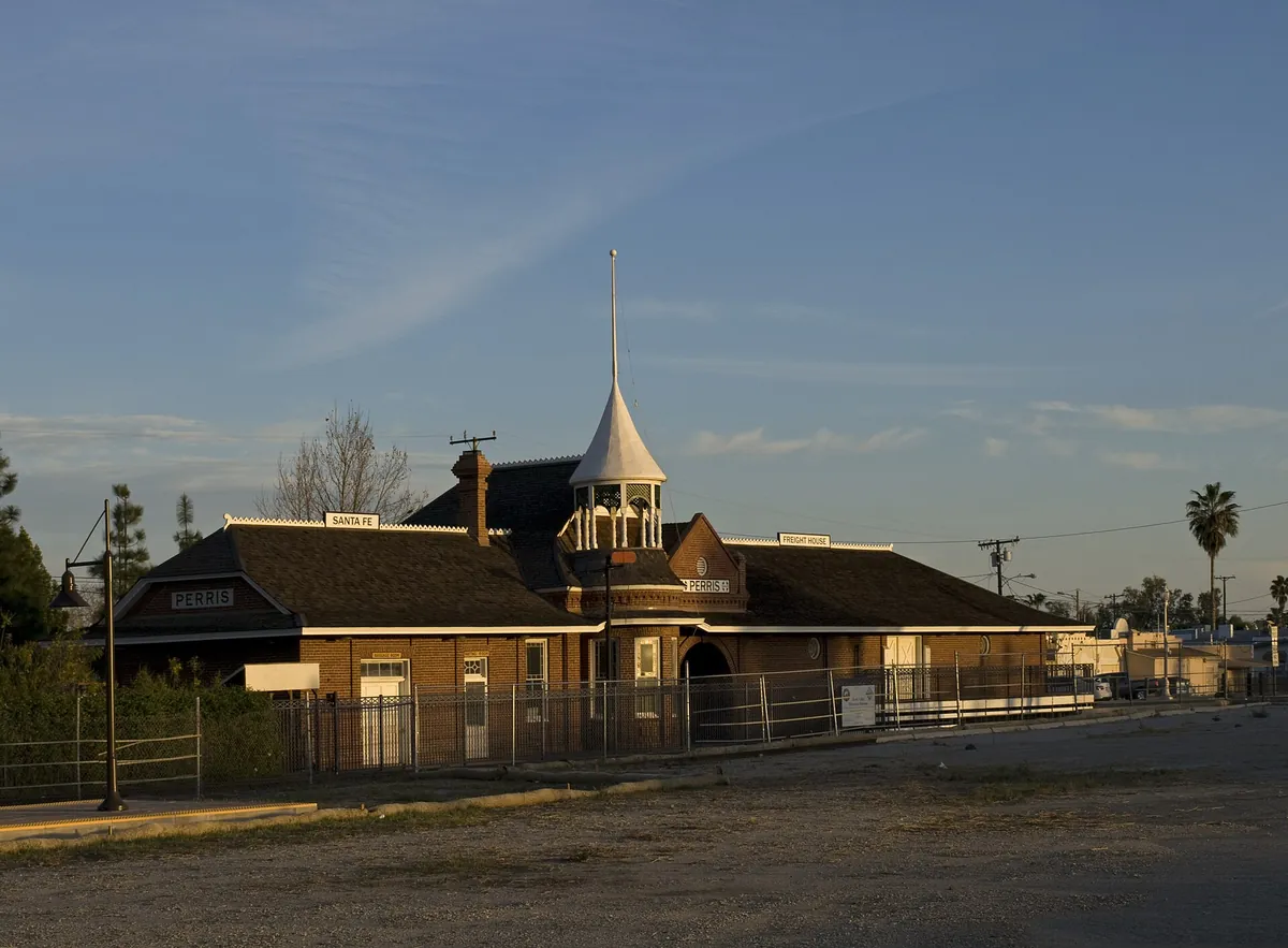 The historic Santa Fe railroad depot in Perris California, a brick building with a steep roof and a white tower